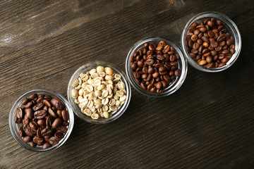 Coffee beans in saucers on wooden background