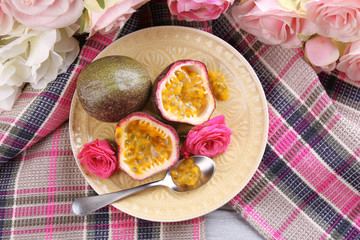 Passion fruit on plate on color wooden background