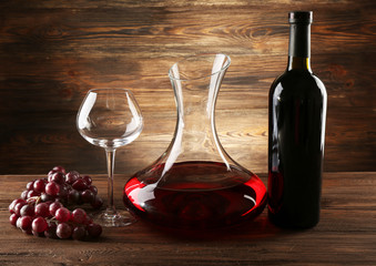 Glass carafe of wine on wooden background