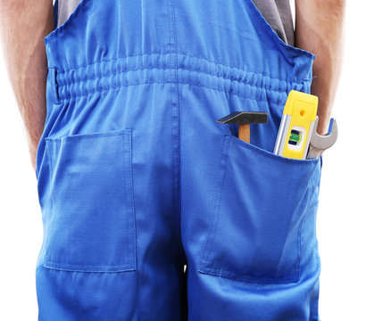 Man in coveralls with tools in his pocket isolated on white