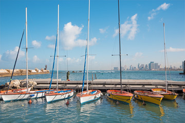 Fototapeta na wymiar The little harbor and yachts under old Jaffa and Tel Aviv