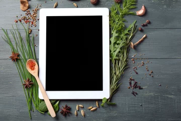 Crédence de cuisine en verre imprimé Herbes Digital tablet with fresh herbs and spices on wooden background