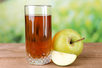 Glass of healthy fresh juice of apples on wooden background