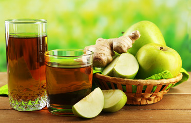 Glass of healthy fresh juice of apples and ginger on wooden background