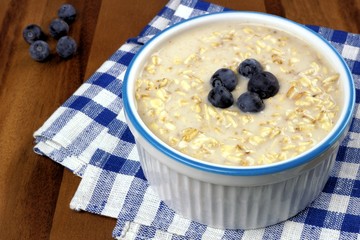 Breakfast oatmeal bowl with milk and blueberries