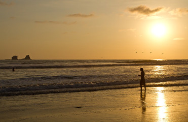 Silhouette of young man enjoying the beach view during sunset