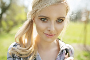 Naklejka premium Closeup portrait of the blond lady in the summer garden