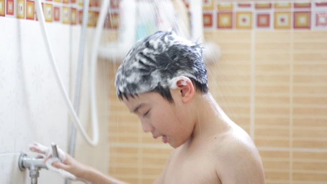 Young Asian boy washing his hair in bathroom