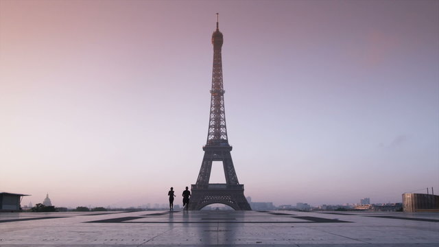 couple running in front of the Eiffel tower