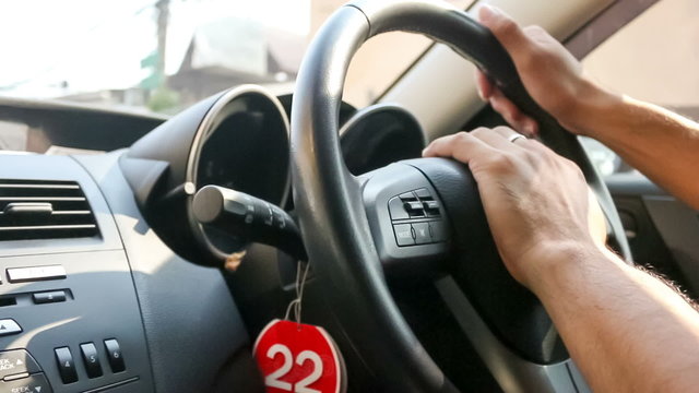 Close up of nervous male hands on steering wheel