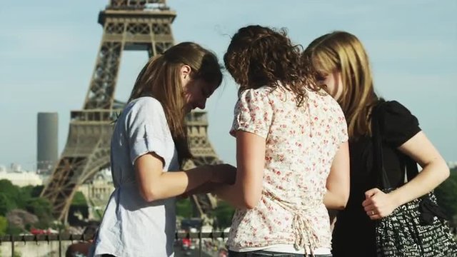 MS Three young women taking photo of Eiffel Tower / Paris, France