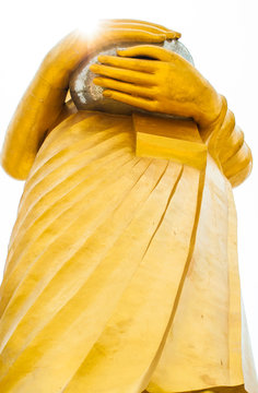 View under golden Buddha standing white background.