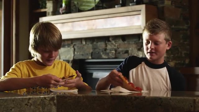 MS Two boys (12-13) eating pizza, American Fork, Utah, USA