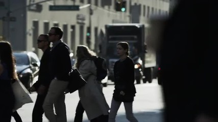 Slow motion medium shot of bustling city street and crosswalk / New York City, New York, United States