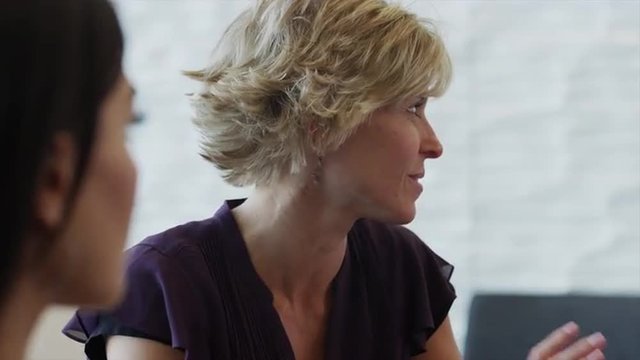Close up of businesswoman talking to co-workers / Provo, Utah, United States, 