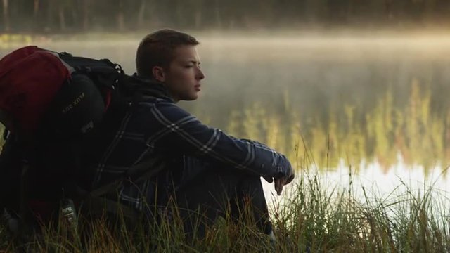 MS Young man sitting on edge of lake, Uinta Mountains, Utah, USA