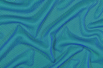 Fototapeta na wymiar Blue crumpled nonwoven fabric on a green