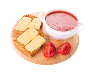 Bowl of tomato soup on board.