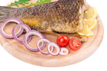 Grilled carp with lemon and tomatoes.