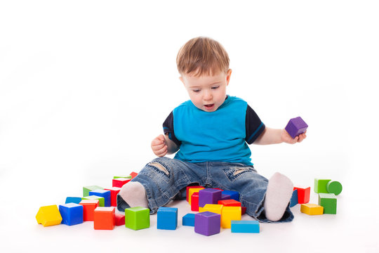 Baby boy playing with colorful toys bricks
