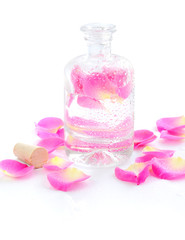 Obraz na płótnie Canvas Bottle of essential oil and petal pink rose isolated on white