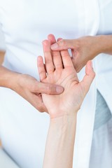 Physiotherapist massaging her patients hand