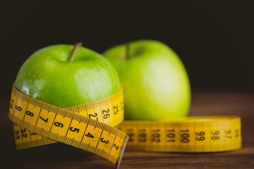 Green apples with measuring tape