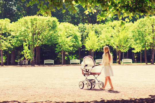 happy mother with stroller in park