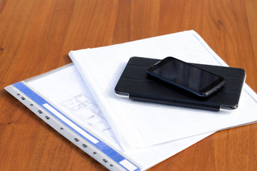 phone with the tablet and documents on a table