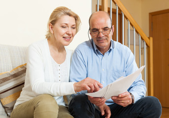Mature couple with documents at home