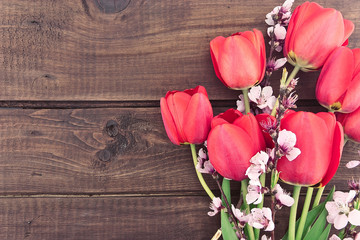 Fototapeta na wymiar Bouquet of red tulips on a wooden background