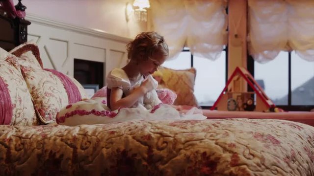 Medium shot of girl playing with stuffed animals on bed / Sandy, Utah, United States