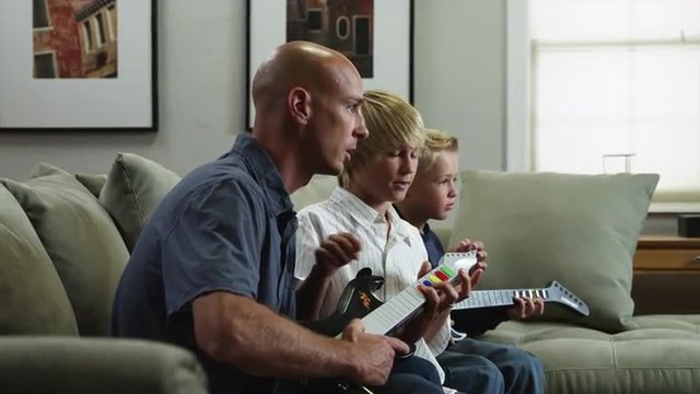 MS DS Father with two sons (8-9, 10-11) learning how to playelectric guitar / Orem, Utah, USA