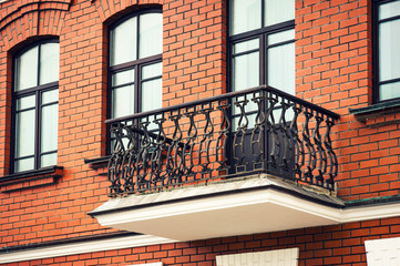 Balcony with wrought iron railings of a brick building