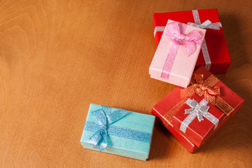 Colored gift boxes with decorative bows on wooden background. Se