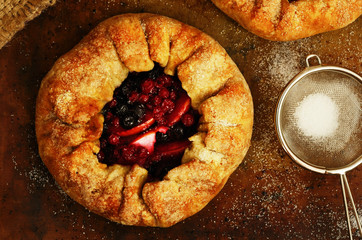 Homemade open pies or galette with apples and berry mix