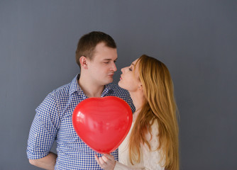 Beautiful couple in love with red balloon heart 