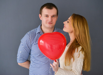 Beautiful couple in love with red balloon heart 