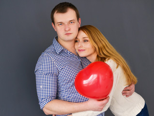 Beautiful couple in love with red balloon heart 