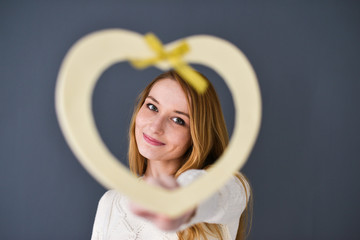 Closeup portrait of young female holding heart shape
