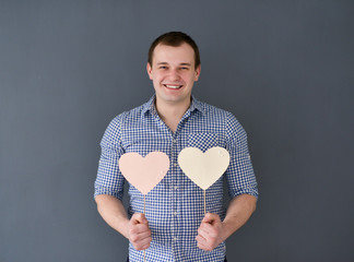 Young man holding two hearts. Valentine's Day.
