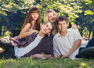 Four young people on the green lawn in park