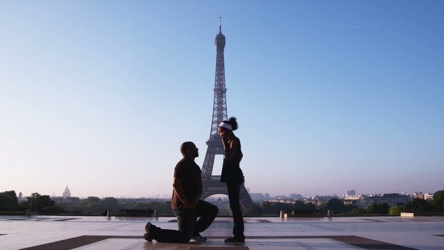 man proposing marriage to woman in front of the Eiffel tower