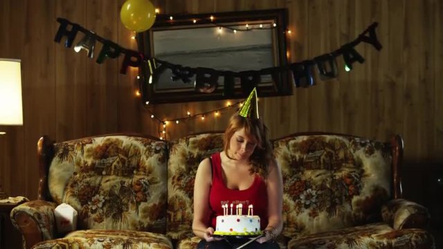 MS TD Young woman with birthday cake, on living room sofa/ Orem, Utah, USA