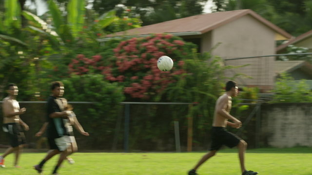 Panning slow motion wide shot of soccer teams playing on field / Esterillos, Puntarenas, Costa Rica