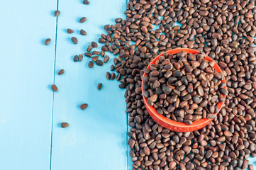 Pine nuts in a ceramic bowl on light background. Cedar nut close