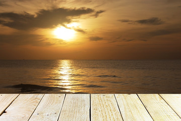 Fototapeta na wymiar Wood terrace and Cloudy orange sunset over sea