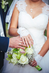 Obraz na płótnie Canvas Bride and groom holding bridal bouquet close up