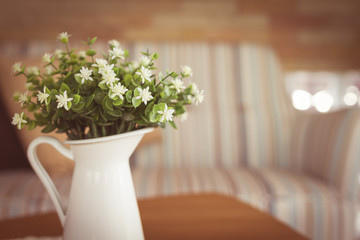 little white flower in vase on wooden table