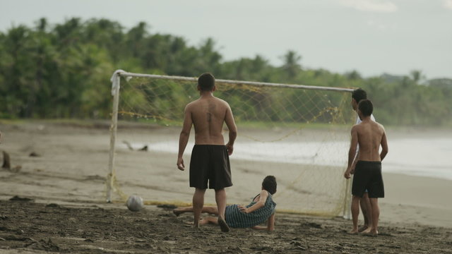 Wide slow motion panning shot of soccer team scoring on beach / Esterillos, Puntarenas, Costa Rica